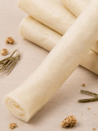 A close-up of ches arranged on a light beige surface with a few rosemary sprigs and small crumbs nearby.