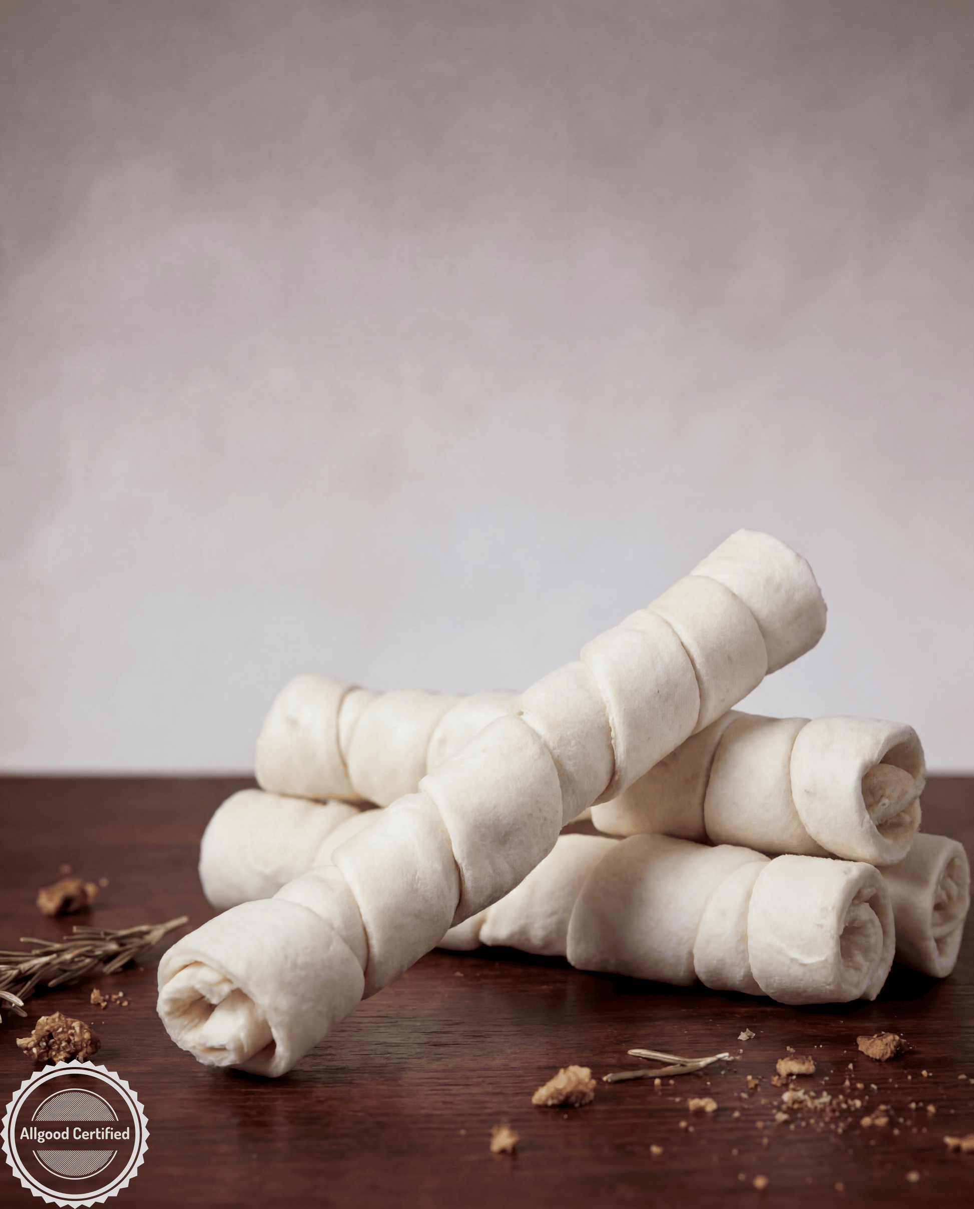 Rolled beef cheek on a wooden surface with a neutral background