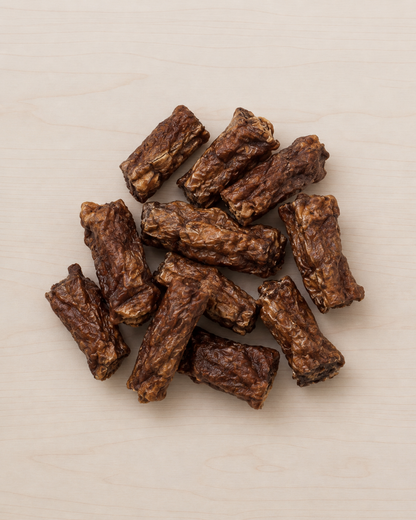 Allgood dog treat training treats arranged on a light beige wood-grain surface.